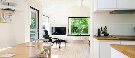 A modern kitchen with a wooden countertop and a large window.