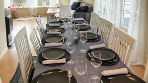 A dining table set with plates, glasses, and cutlery, surrounded by white chairs. - 12 Person Holiday Home in Davik (Bremanger)