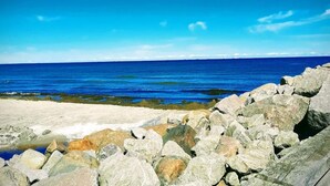 Una costa rocciosa con cielo azzurro e mare calmo.