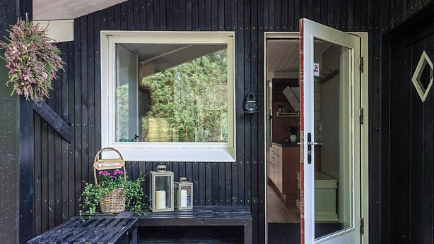 Facciata in legno con una porta che dà su un'area cucina.