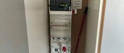 A utility panel with various switches and indicators, a sign with text, and a red pole.