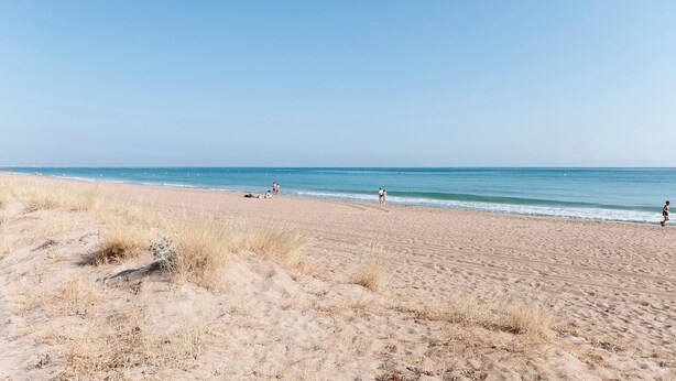 A sandy beach with a clear sky and calm sea. - - House In (Denia)