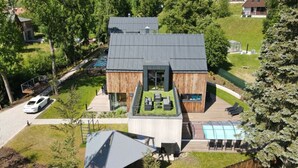 A modern house with a large deck, a swimming pool, and a car parked nearby. - Cerny Dul Kcmv115 Comfortable Holiday Residence (Cerny Dul)