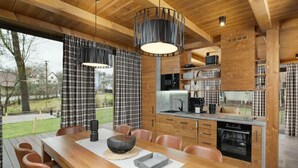 A modern kitchen with wooden cabinetry, a central island, and pendant lighting. - Cerny Dul Kcmv115 Comfortable Holiday Residence (Cerny Dul)