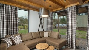 A modern living room with a large sectional sofa, two round wooden tables, and plaid curtains. - Cerny Dul Kcmv115 Comfortable Holiday Residence (Cerny Dul)