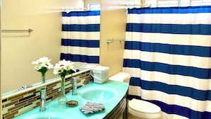 Bañera con ducha, toallas, jabón, papel higiénico