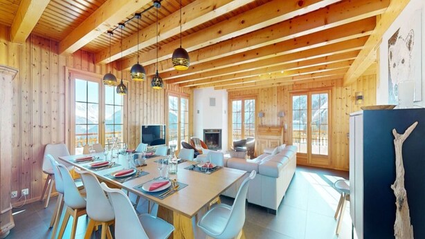 A spacious dining area with a long table and chairs, a sofa, and a television. - Chalet in Thyon-les Collons (Vex)