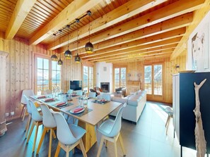 A spacious dining area with a long table and chairs, a sofa, and a television. - Chalet in Thyon-les Collons (Vex)