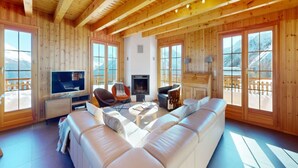 A spacious living room with a large sofa, a television, and a fireplace. - Chalet in Thyon-les Collons (Vex)