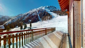 A balcony with a view of a snow-covered mountain and forest. - Chalet in Thyon-les Collons (Vex)