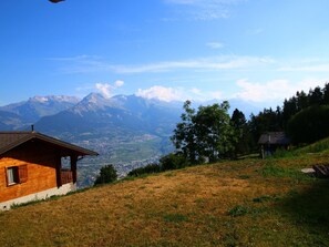 A wooden cabin with a balcony overlooking a mountainous landscape. - Authentic Apartment With Mountain Views (Veysonnaz)