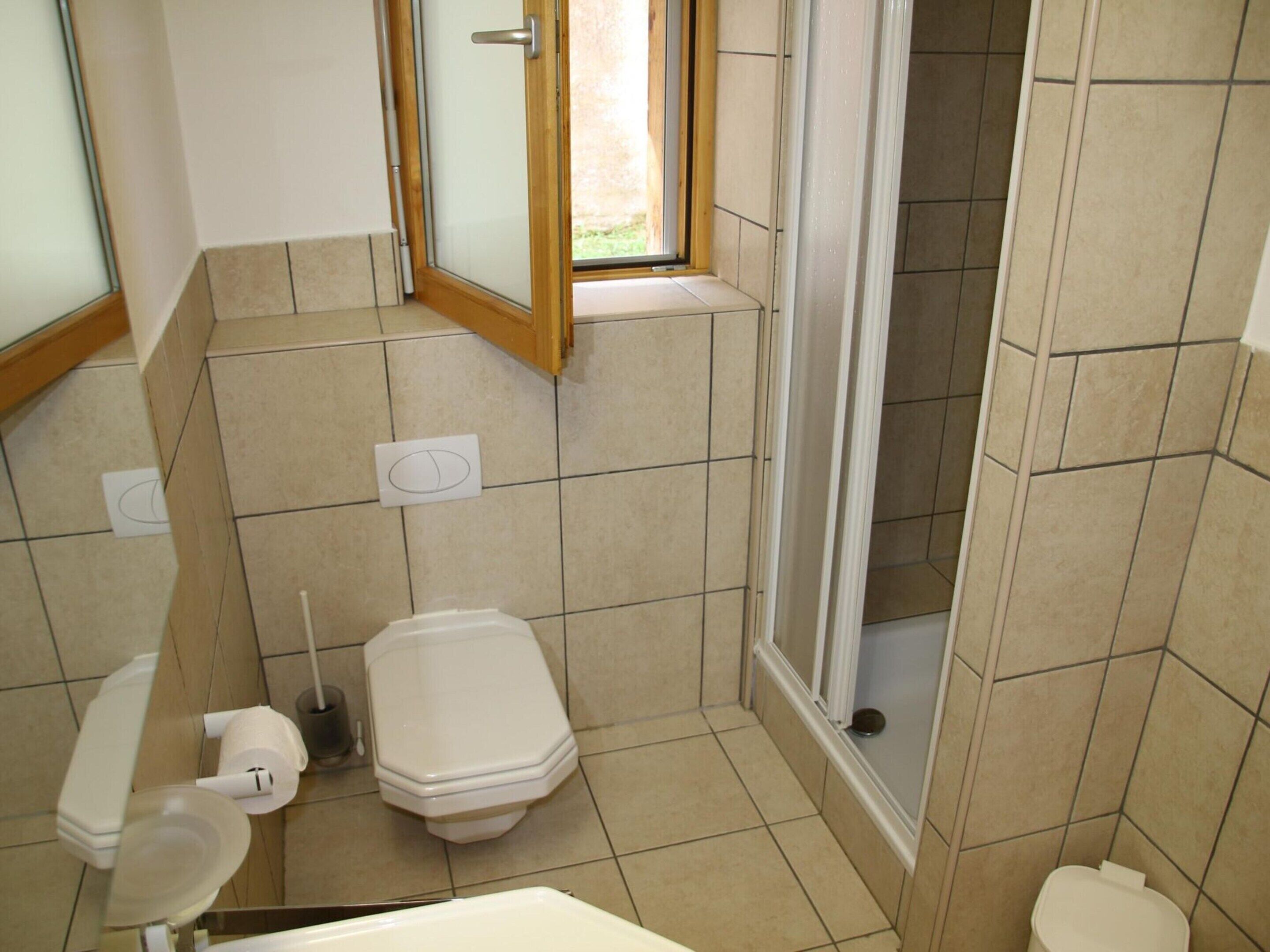 A bathroom with a toilet, bidet, and shower area.
