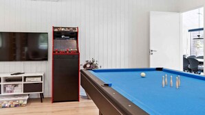 Een pooltafel met een blauwe viltkleed, een keu en verschillende witte poolballen.