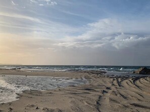 A beach with visible footprints and waves. - 5 Star Holiday Home in Dronningmolle (Dronningmolle)