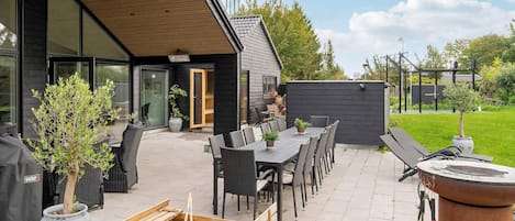 A patio area with outdoor furniture, a barbecue grill, and a wooden playhouse.