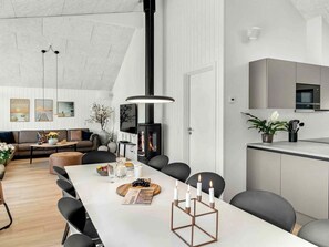 Uma sala de estar moderna com sofá, mesa de centro e área de jantar com cadeiras e mesa.