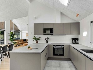 A modern kitchen with a built-in oven, a microwave, and a coffee maker. - 5 Star Holiday Home in Dronningmolle (Dronningmolle)