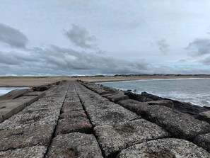 A concrete pathway leading to a beach with a cloudy sky. - 5 Star Holiday Home in Vestervig (Vestervig)