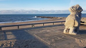 A stone lion statue on a paved walkway by the ocean. - 5 Star Holiday Home in Vestervig (Vestervig)
