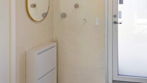 A room with a door, a wall-mounted mirror, and a small cabinet. - 5 Star Holiday Home in Vestervig (Vestervig)
