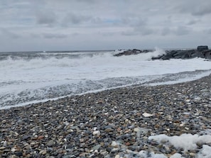 Una playa rocosa con olas rompiendo en la orilla.