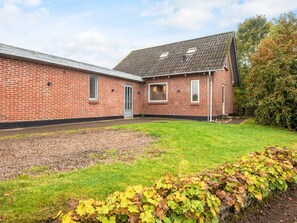 A brick building with a flat roof, a door, and windows. - 6 Person Holiday Home in Ansager (Ansager)