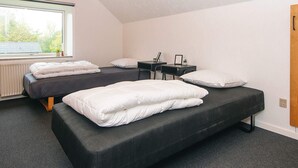 A room with two beds, a window, a radiator, and a wooden door. - 6 Person Holiday Home in Ansager (Ansager)