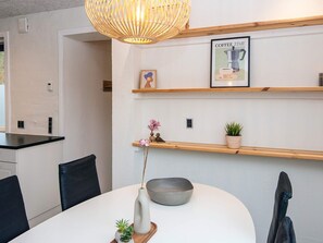 A modern kitchen with white walls, wooden shelves, and a dining table with chairs. - 6 Person Holiday Home in Ansager (Ansager)