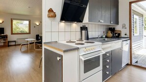 Une cuisine moderne dotée d’un îlot central, d’un four encastré et d’appareils électroménagers en acier inoxydable.