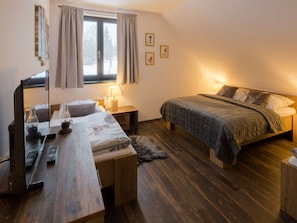 A bedroom with a bed, bedside tables, a desk with a computer, and a window with curtains. - Welcoming Villa With Amenities (Trutnov)