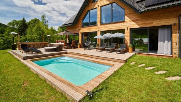 A modern wooden house with a swimming pool, outdoor seating, and large windows. - Welcoming Villa With Amenities (Trutnov)