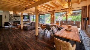 A spacious living area with a stone fireplace, wooden ceiling beams, and a large dining table. - Welcoming Villa With Amenities (Trutnov)