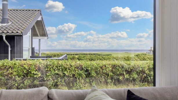 Una sala de estar con vista a una playa y una casa.