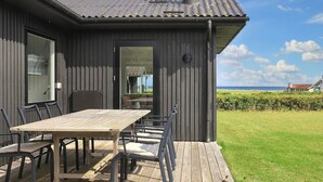 Una casa moderna con terraza, mesa y sillas.