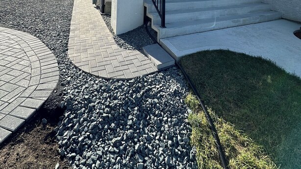 A modern two-story house with a flat roof, a covered porch, and a paved driveway. - Cozy 1BR Suite at Winnipeg South (Winnipeg)
