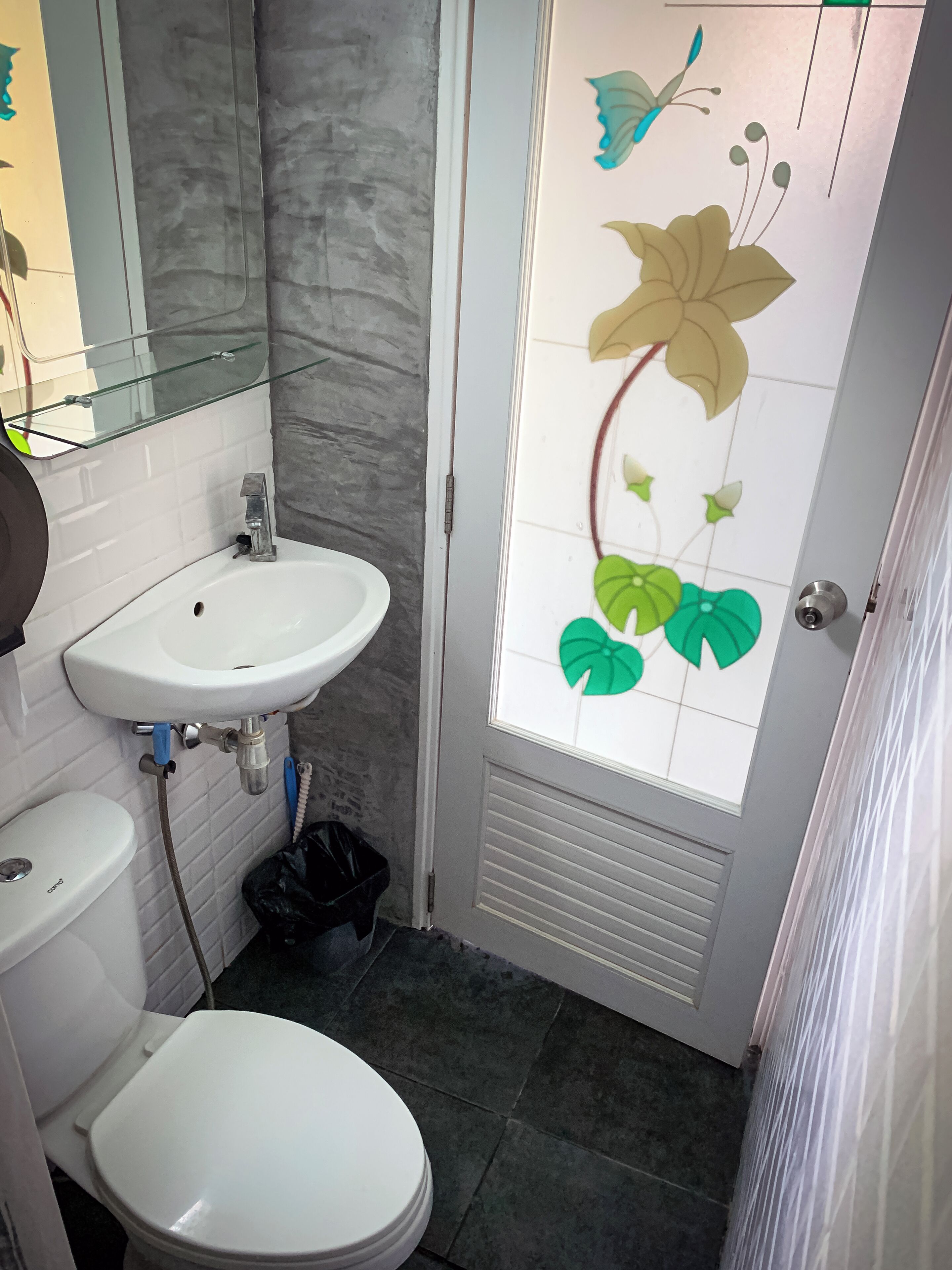 Ein Badezimmer mit weißem Waschbecken, WC und einer Duschkabine aus Glas.