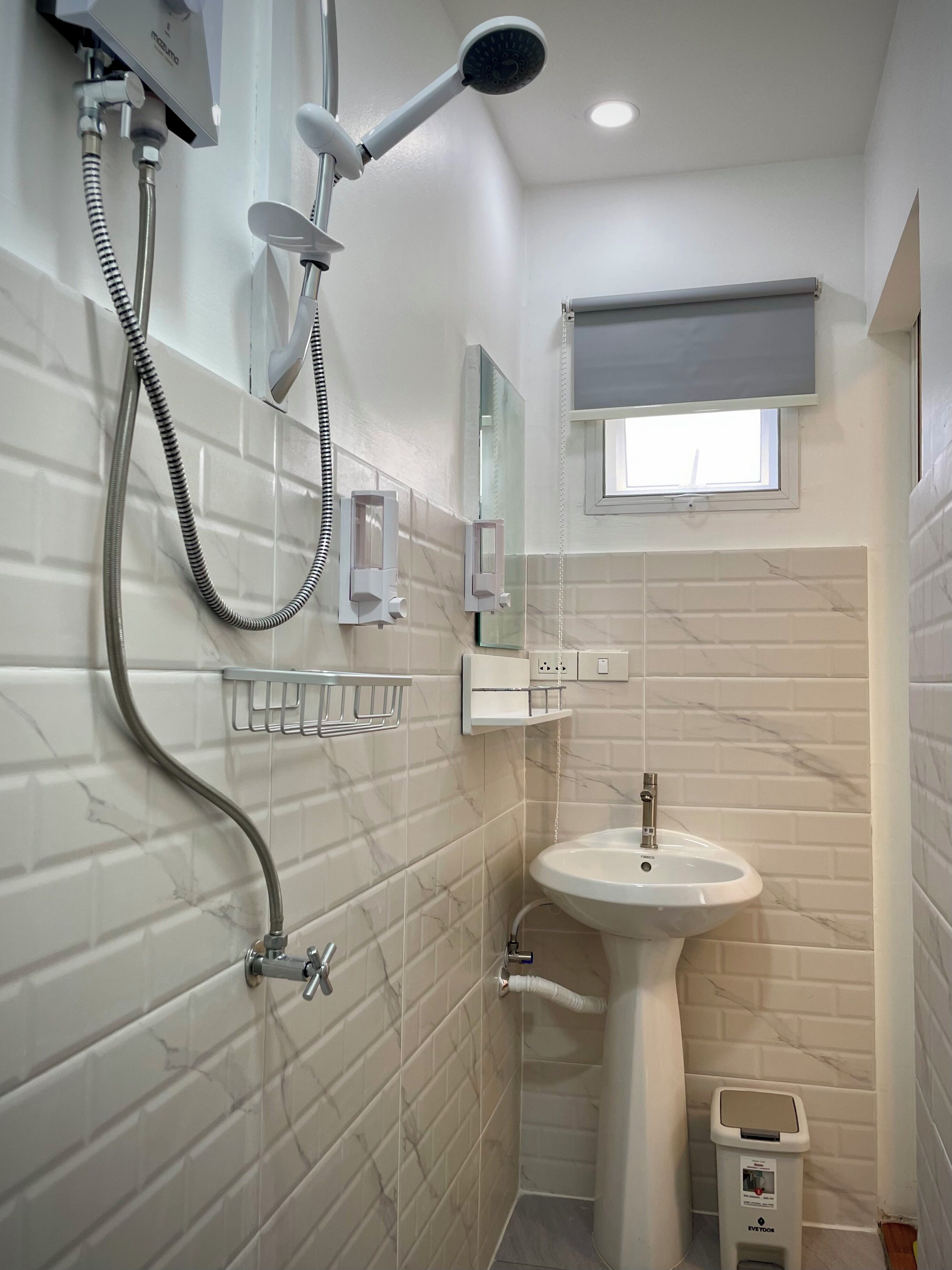 A modern bathroom with a shower, a sink, and a mirror.