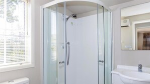 A modern bathroom with a glass-enclosed shower, a white sink, and a toilet. - Copper John, close to the Ski Fields here in the McKenzie. Quiet and private. (Middle Valley)