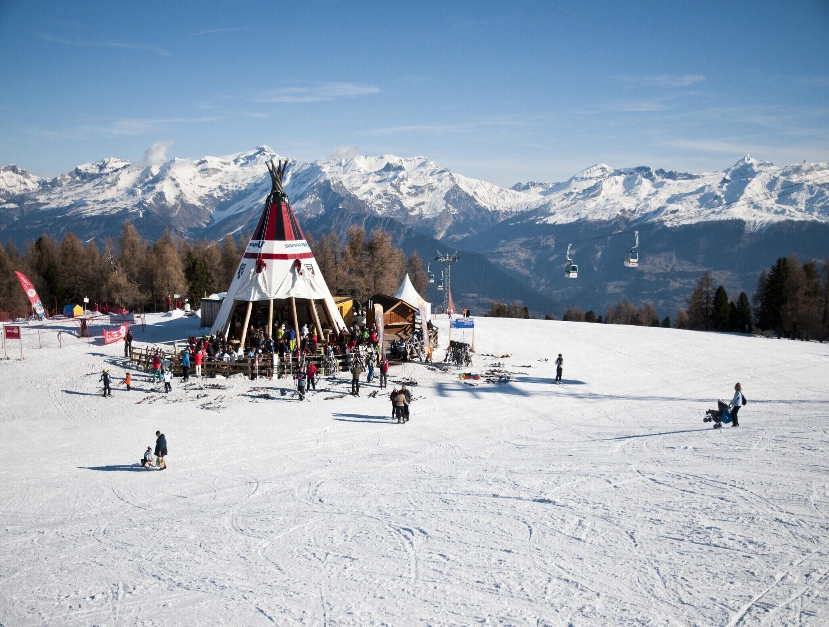 A ski resort with a prominent ski lift and a snow-covered mountain backdrop.