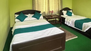 A room with two beds, a ceiling fan, and a window with curtains. - New Pokhara Lodge, Lakeside (Pokhara)