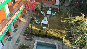 A multi-story building with balconies, a courtyard with outdoor seating, and a swimming pool. - New Pokhara Lodge, Lakeside (Pokhara)