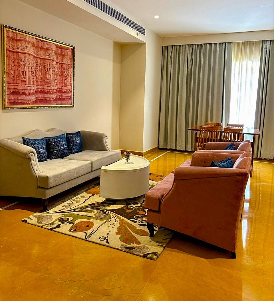 A living room with a sofa, a loveseat, a coffee table, and a patterned rug.
