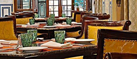 A traditional dining area with wooden tables and yellow upholstered chairs.