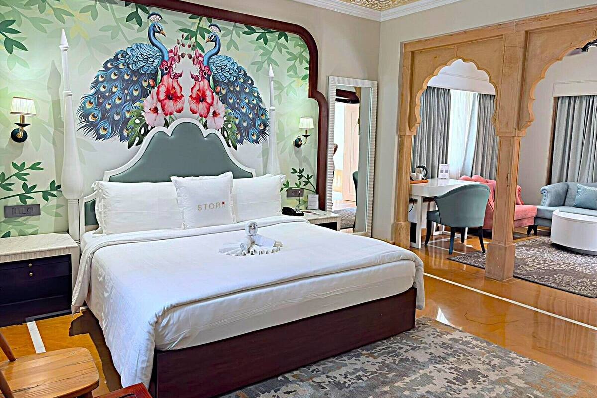Ein Hotelzimmer mit einem großen Bett, einem Schreibtisch, einem Stuhl und einem Spiegel.