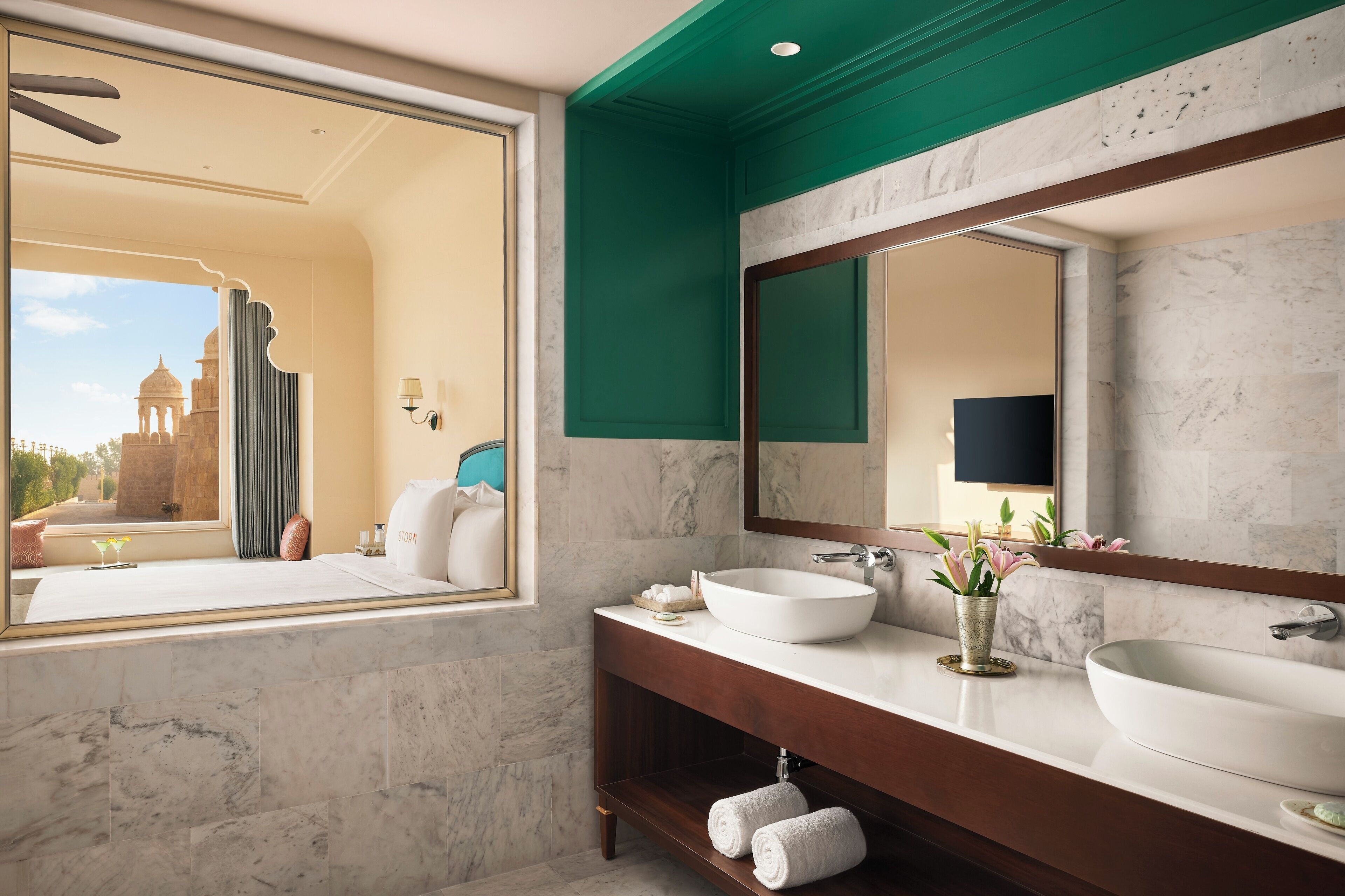 A modern bathroom with a large window, two sinks, and a mirror.