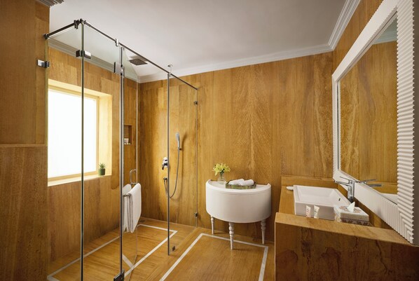 A modern bathroom with a wooden wall, a glass shower enclosure, a white sink, and a large mirror. - Storii By ITC Hotels Jaisalmer (Jaisalmer)
