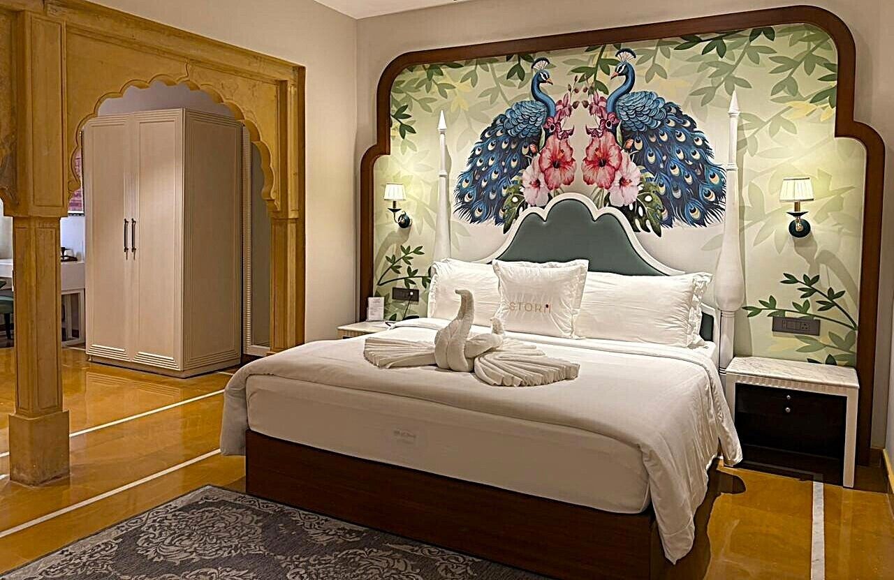 Un dormitorio con una cama grande, un cabecero decorativo, dos mesitas de noche y un armario.