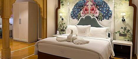Un dormitorio con una cama grande, un cabecero decorativo, dos mesitas de noche y un armario.