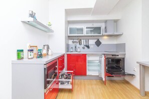 A compact kitchen with a built-in oven, a microwave, and a refrigerator.