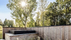 Una terraza exterior de madera con un banco integrado y una pared de madera.
